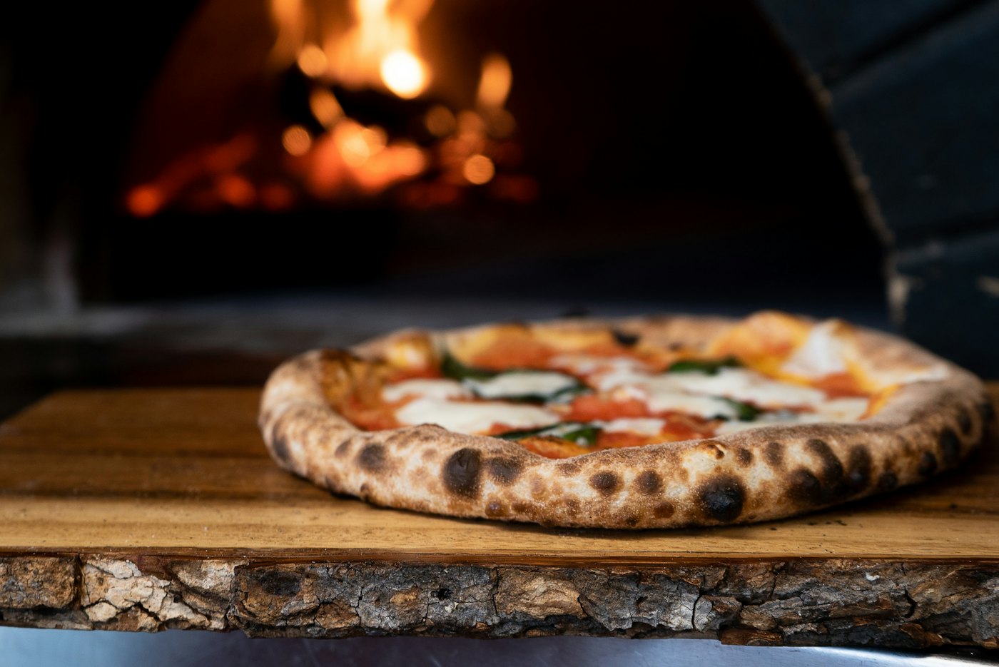 Pizza margherita appena sfornata davanti al forno